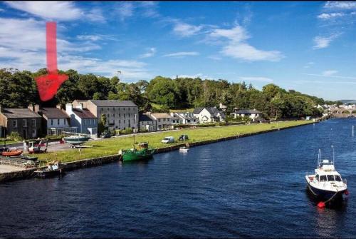 a boat is docked at a dock on a river at Beautiful renovated stone house for Dog friendly, Quayside location in Newport