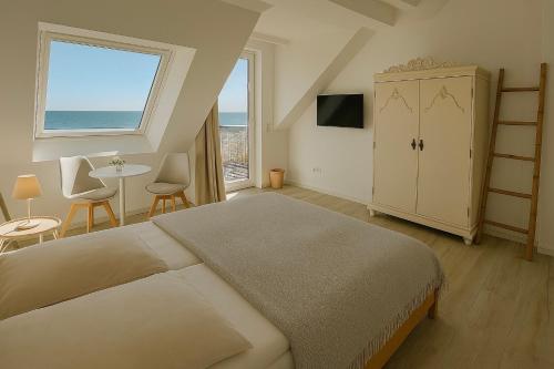 a bedroom with a bed and a table and a window at Lodge am Meer in Glücksburg