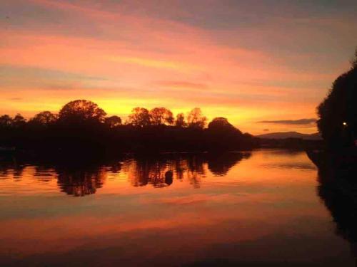 a sunset over a river with trees in the background at Beautiful renovated stone house for Dog friendly, Quayside location in Newport