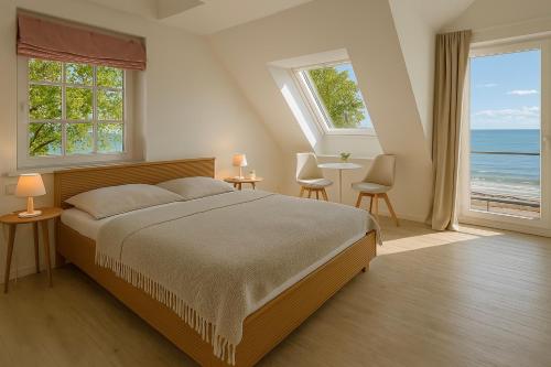 a bedroom with a bed and a view of the ocean at Lodge am Meer in Glücksburg