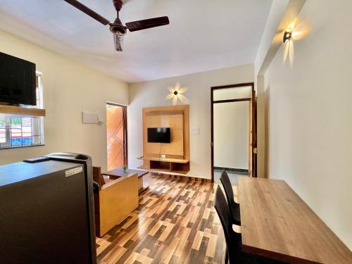 a living room with a dining room table and a television at Lykke Suites- 2-min Drive to Colva Beach-By Goan Felicidade Hospitality PVT LTD in Colva