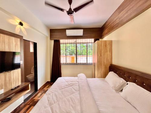 a bedroom with a large bed and a window at Lykke Suites- 2-min Drive to Colva Beach-By Goan Felicidade Hospitality PVT LTD in Colva