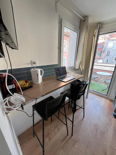 - une cuisine avec un bureau et un ordinateur portable dans l'établissement Studio Cosy centre ville Grenoble, à Grenoble