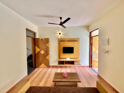 a living room with a ceiling fan and a table at Lykke Suites- 2-min Drive to Colva Beach-By Goan Felicidade Hospitality PVT LTD in Colva