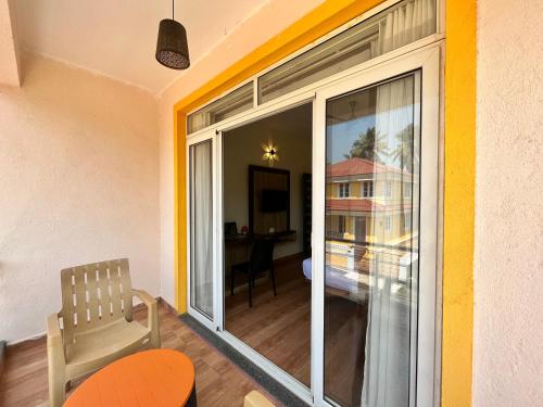 a room with a large sliding glass door with a chair at Lykke Suites- 2-min Drive to Colva Beach-By Goan Felicidade Hospitality PVT LTD in Colva