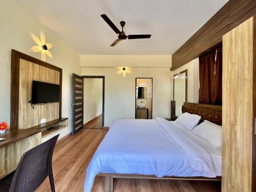 a bedroom with a bed and a ceiling fan at Lykke Suites- 2-min Drive to Colva Beach-By Goan Felicidade Hospitality PVT LTD in Colva