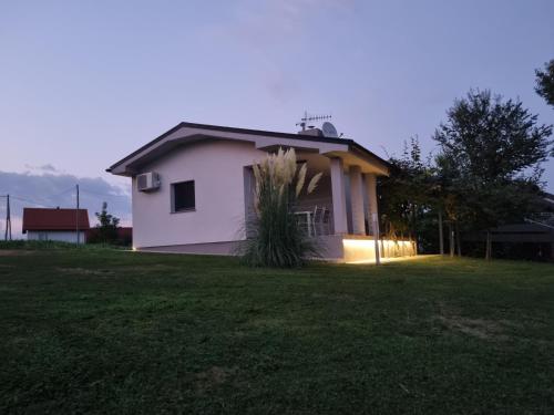 a white house in a field with a grass yard at NA OFF in Radenci