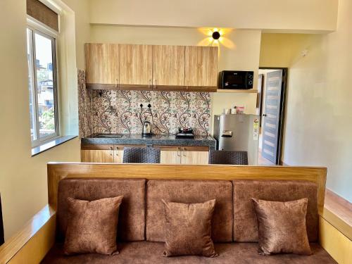 a living room with a couch in front of a kitchen at Lykke Suites- 2-min Drive to Colva Beach-By Goan Felicidade Hospitality PVT LTD in Colva