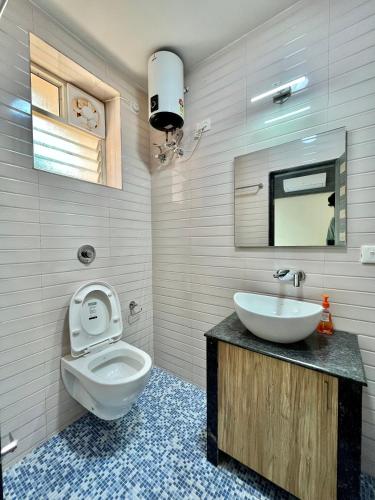a bathroom with a toilet and a sink at Lykke Suites- 2-min Drive to Colva Beach-By Goan Felicidade Hospitality PVT LTD in Colva