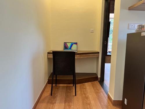 a small table with a laptop on top of it at Lykke Suites- 2-min Drive to Colva Beach-By Goan Felicidade Hospitality PVT LTD in Colva