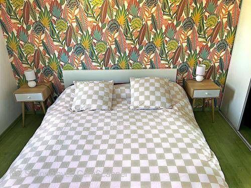 - une chambre avec un lit doté d'un couvre-lit à damier et d'un papier peint dans l'établissement Superbe duplex cœur de ville 3 étoiles, à Jonzac