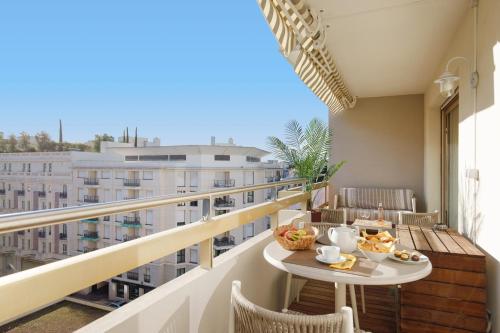 - un balcon avec une table et de la nourriture dans l'établissement Le Palais Royal Elégant Confortable -Balcon 100 mètres Croisette, à Cannes