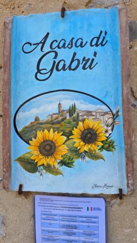 a sign on a wall with sunflowers on it at a casa di Gabri in Montefollonico