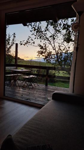 a view of a deck with a picnic table and a view of the sunset at Domek pod jabloní in Tichá