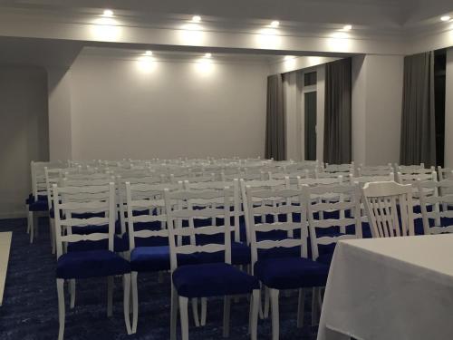 a conference room with white tables and blue chairs at Cimenoglu Hotel in Denizli