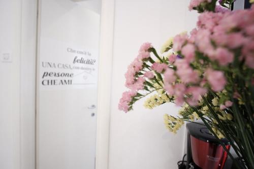 a vase of pink flowers sitting next to a door at Cinque Terre Bridge in La Spezia