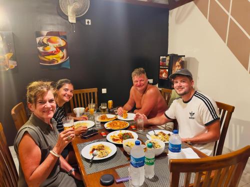 a group of people sitting around a table eating food at White Villa Airport Transit Hotel in Katunayake
