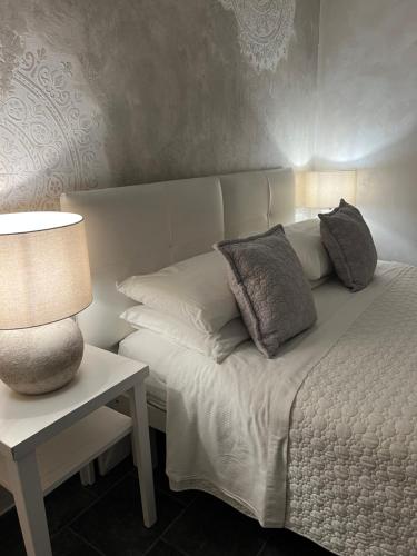 a bed with pillows and a lamp on a table at Borgo di Santa Barbara in Santa Domenica