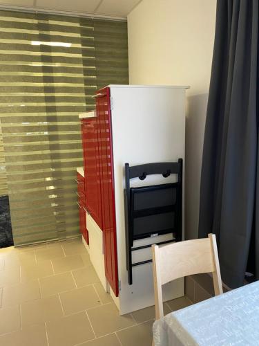 a red and white refrigerator in a room with a chair at Apartment Seehund in Kiel