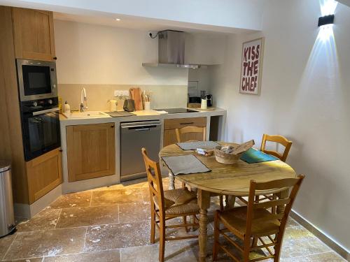 une cuisine avec une table et des chaises dans une cuisine dans l'établissement La terrasse du château, à Le Barroux