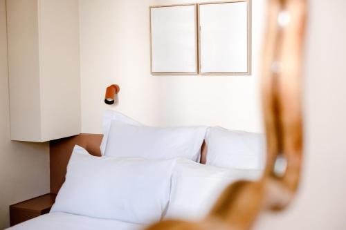 1 Schlafzimmer mit 2 Fenstern und weißen Kissen in der Unterkunft Babylon Popincourt in Paris