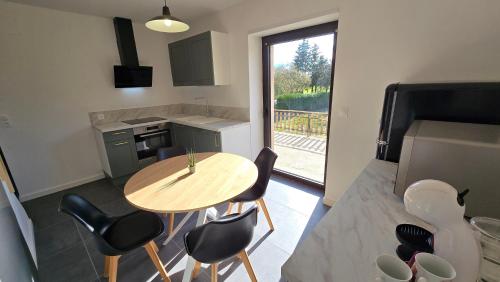 une cuisine avec une table et des chaises dans une pièce dans l'établissement Charmante maison, entière avec jardin et terrasse !, à Sarralbe