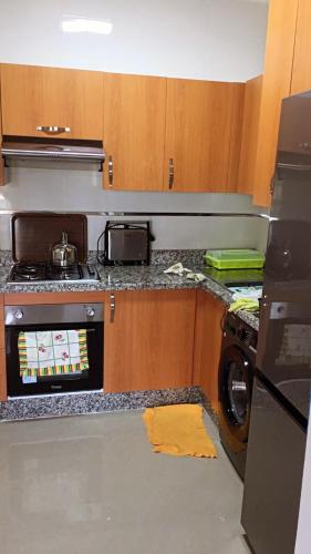 a kitchen with a stove and a washing machine at Marina Golf Appartement HS in Asilah