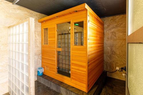 una ducha de madera con puerta de cristal en una habitación en La Villa Vétiver, en Saint-Joseph