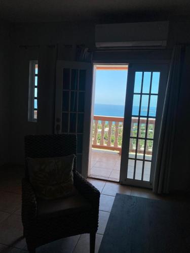 a living room with a chair and a view of the ocean at The Pink House, Saint Thomas, Ocean View in Contant