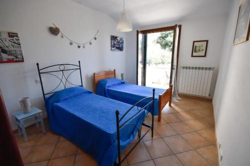 a bedroom with two beds with blue sheets at Cà du Scéndego in Lingueglietta