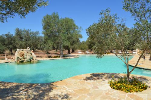 einen Pool mit Wasser in einem Park mit Bäumen in der Unterkunft Masseria Le Celline in Nardò