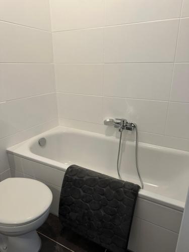 a white bathroom with a toilet and a bath tub at 3-Zimmer Ferienunterkunft in Bad Salzuflen