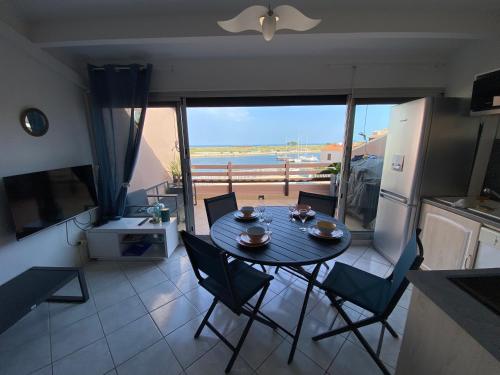 - une table et des chaises dans la cuisine avec vue sur l'océan dans l'établissement Appartement sur la marina vue mer panoramique, à Saint-Cyprien