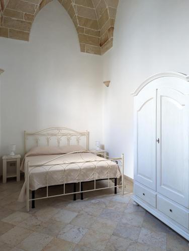 a bedroom with a bed in a white room at Dimora Matteotti in Nardò