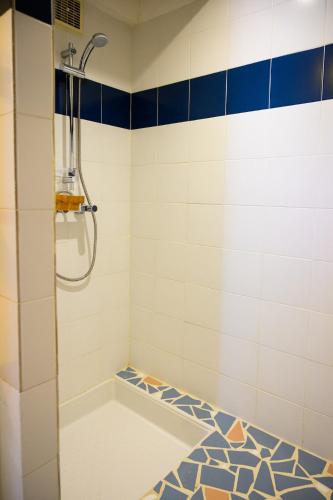 une salle de bain avec douche aux carreaux bleus et blancs dans l'établissement Un Cabanon en Camargue, à Arles
