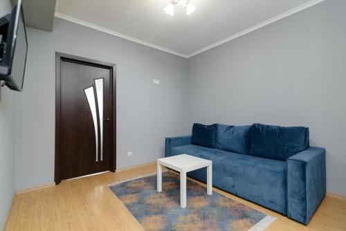 a living room with a blue couch and a table at ERA RENT Apartments in Chişinău