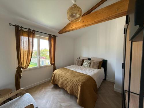 une chambre avec un lit et une grande fenêtre dans l'établissement Appartement cosy et élégant, à Ambarès-et-Lagrave