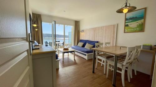 une cuisine et un salon avec une table et un canapé dans l'établissement Ty Jean - Piscine - plage à pied, à Crozon