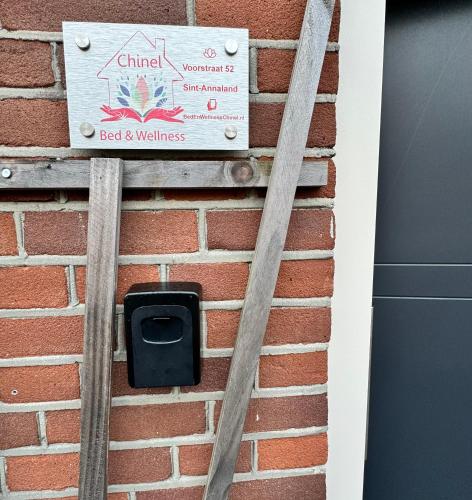 a sign on the side of a brick wall at Bed & Wellness Chinel Luxe vakantiehuis met Sauna's en Bubbelbad in Sint Annaland