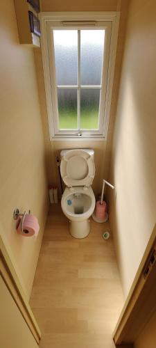 Elle comprend une petite salle de bains pourvue de toilettes et d'une fenêtre. dans l'établissement Mobil home 4 à 6 pers camping 5 étoiles proche Deauville, à Saint-Arnoult