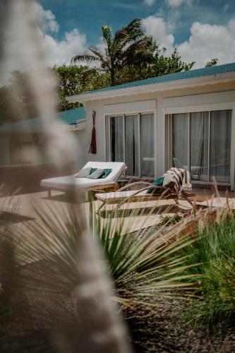a patio with a lounge chair and a house at Villa Manika vue mer in Le Moule