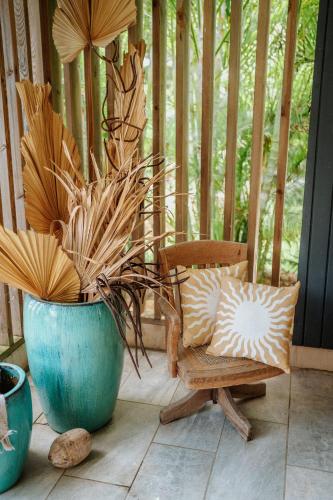 a porch with a chair and a potted plant at Villa Manika vue mer in Le Moule