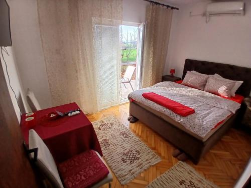 a bedroom with a bed with red pillows on it at Airport home Radinovic in Podgorica