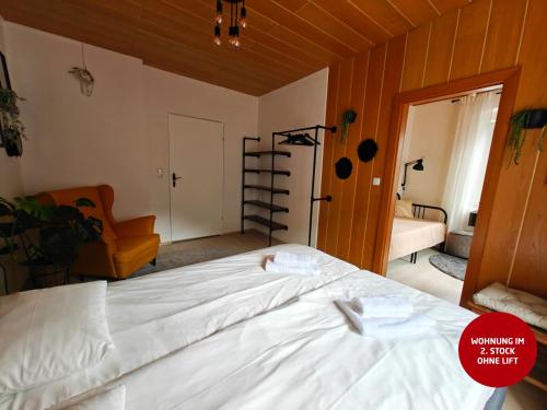 a bedroom with a large white bed with a chair at Ferienwohnungen Meier in Ebensee