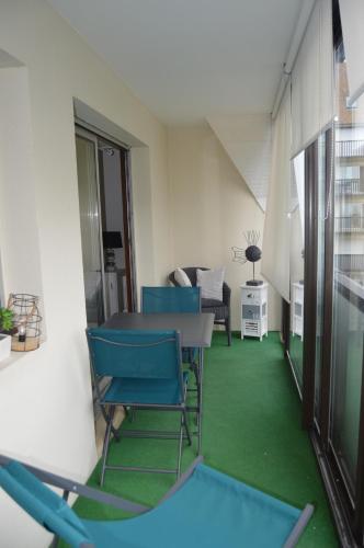 Cette chambre dispose d'une table, de chaises et d'un sol vert. dans l'établissement Appartement bord de mer, à Villers-sur-Mer