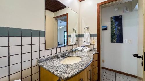 a bathroom with a sink and a mirror at Apto Cond. Porto Ventura 3 quartos in Florianópolis