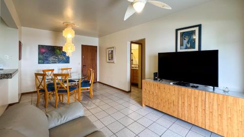 a living room with a television and a table and chairs at Apto Cond. Porto Ventura 3 quartos in Florianópolis