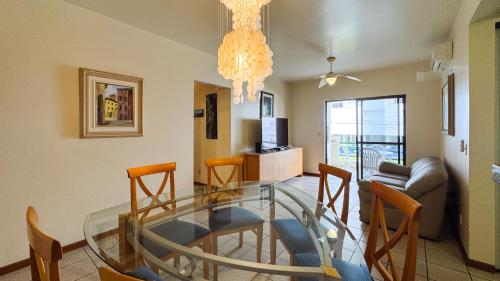 a living room with a glass table and chairs at Apto Cond. Porto Ventura 3 quartos in Florianópolis