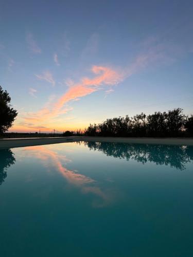 a pool of water with a sunset in the background at Il Podere di Remo in Collesalvetti