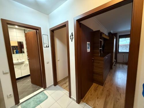 a hallway with two doors and a bathroom with a sink at Denitsa Apartment in Borovets